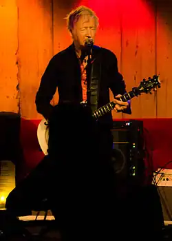 An older man playing a guitar
