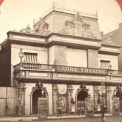 Photograph of the building in a different alteration, with a few people in front watching the photo being taken