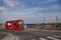 A route EL1 bus on the new Northgate Road extension passing the newly opened Barking Riverside pier in summer 2022.