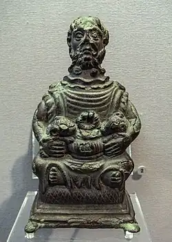 The Étang-sur-Arroux statuette of Cernunnos. He has two torcs and two holes at the top of his head, probably to receive deer antlers. Above his ears are two small faces.: no 10 