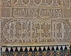 Calligraphy in the Salón de Embajadores in the Alhambra, Granada (14th century): above is the Nasrid motto ("There is no conqueror but God") in cursive script, repeated more than once, while below is a larger inscription in "Knotted" Kufic