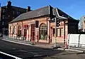 The station building seen from the new road bridge, the original arched doorways converted into windows and new narrow doors formed from central window openings