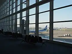 Seating in Haneda Airport in front of a window with view to the runway.