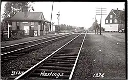 A postcard showing a small wooden train station in a rural area