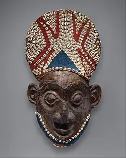 Royal mask; by artists of the Bamum people (Cameroon); before 1880; wood, copper, glass beads, raffia and shells; height: 66 cm; Metropolitan Museum of Art[107]