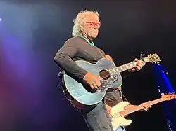 Musician Henry Paul playing an acoustic guitar.
