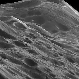 Image 7 Iapetus Photo credit: Cassini orbiter A close-up of 10 km (6.2 mi) high mountains within the equatorial ridge on Saturn's moon Iapetus, photographed by the Cassini orbiter. Above the middle of the image can be seen a place where an impact has exposed the bright ice beneath the dark overlying material. The image was taken on September 10, 2007, with the Cassini spacecraft narrow-angle camera at a distance of approximately 3,870 km (2,400 mi) from Iapetus. More selected pictures