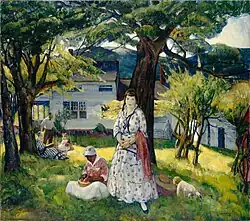 A white family with a black woman are in a lightly forested area in front of a house. In the background is a mountain range.