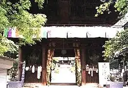 Small wooden gate with two guardian statues in the outer bays.