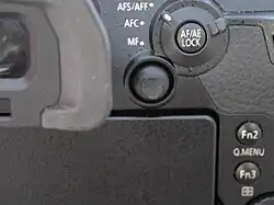 Miniature joystick to be operated by the right thumb, next to an electronic viewfinder