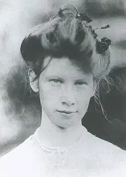 Woman wearing a white dress with her hair in a large bun