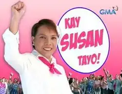 An image of Susan Enriquez raising her left hand, with several people in the pink background. The show title is displayed on the center of the image. The logo of GMA Network is displayed on the upper right side of the image.