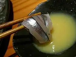 Kibinago sashimi with chopsticks