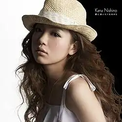 A woman with a tear down her cheek looking to the right.