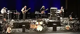King Crimson in Nijmegen on 22 June 2019. Top L–R: Mel Collins, Tony Levin, Jakko Jakszyk, Robert Fripp. Bottom L–R: Pat Mastelotto, Jeremy Stacey, and Gavin Harrison.