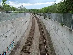 View of a 2-track railway line from above a tunnel portal