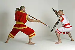 A krabi krabong practitioner with a plong or staff trains with a practitioner wielding mai sok