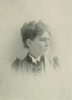 19th-century B&W portrait photo of a woman with her hair in an up-do, wearing a dark blouse with a white collar.