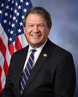 Official House portrait of Latimer in front of the U.S. flag, wearing a black jacket, light blue shirt, and thin red tie.
