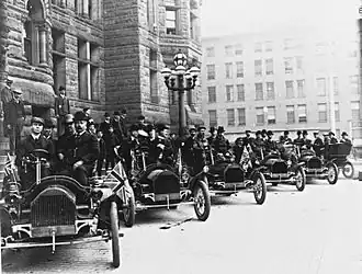 A row of Russell motor cars in front of Toronto city hall in 1909. Tommy Russell is seated in the driver's seat of the first car.