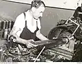 Worker making a shell case on a turret-headed lathe