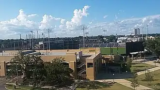 A ballpark in the distance behind a tan concrete parking garage