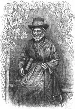 Seated older woman in 19th century clothing, surrounded by a border of leaves.