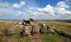 A rectangular stone tomb, with a clear wall around it.
