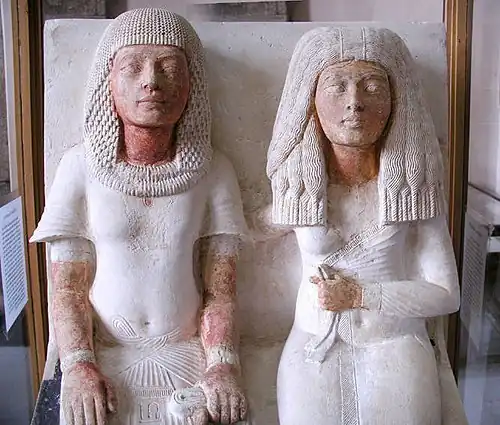 Meryre, a Scribe, and his wife (hieroglyph on his pants, w/ his name)