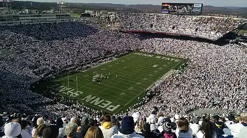 A stadium full of fans dressed in white and navy blue.