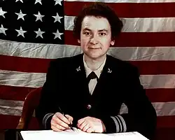 Female WAVE officer sitting at her desk in dress blue uniform