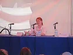 Ringwald seated at a table with a microphone