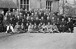A group of men and women, some clergy and some laity, pose for a group photo at a presbytery meeting in Berriew, Wales.