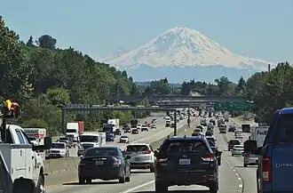 A freeway with a snow-capped mountain in the background