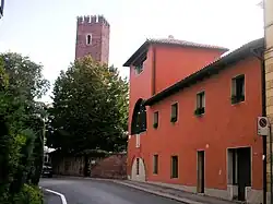 Restored stone turret integrated into a modern building wall, with another tower visible in the background.