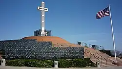 White cross on top of a hill and American flag