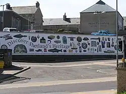 A mural with the text "Discover Shetland's Heritage" and images of archaeological and craft objects