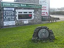 Weathered blue circular plaque bearing the logo of the Mendip Hills Area of Outstanding Natural Beauty