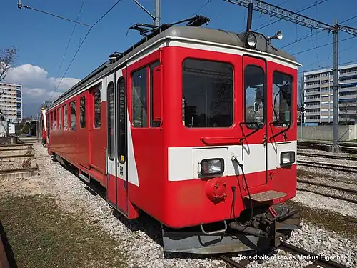 Red and white train next to railway line