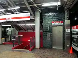 An elevator and stairs viewed from a subway station platform
