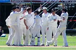 The New Zealand cricket team celebrating a wicket.