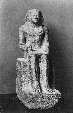 Small statue showing a king seated, wearing the nemes and clenching his right hand