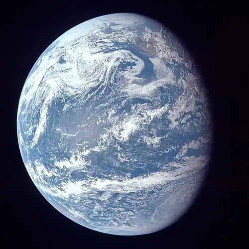 Image 88A view of Earth with its global ocean and cloud cover, which dominate Earth's surface and hydrosphere; at Earth's polar regions, its hydrosphere forms larger areas of ice cover. (from Earth)