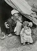 Old and young in the entrance of a tent, 1948[citation needed]