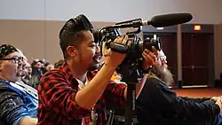 Jan Ochoa producing video content in a seating area at PAX East 2018