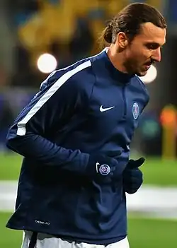 photograph of two men standing next to each other on a football pitch