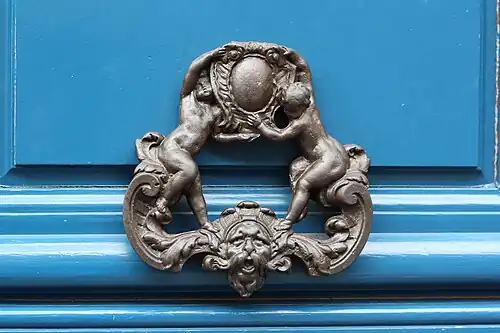 A door knocker with putti holding a cartouche, in Paris