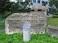 A memorial plaque established by Singapore's National Heritage Board (NHB) in front of the pillbox commemorating the history of the structure.