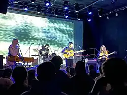 Four musicians perform on a stage