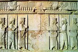 Stone relief depicting two groups of three men facing each other (from Human history)